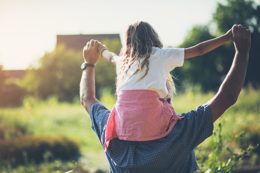 Rear view of a young girl on fathers shoulders